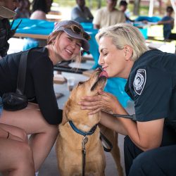 two student and UCF police office getting licked by a dog