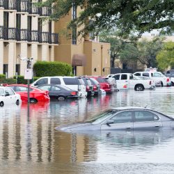 cars underwater in front of a building