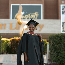 Njeri Kinuthia wearing graduation regalia and smiling