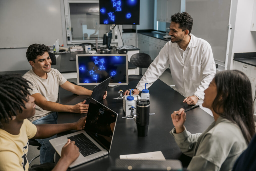 Three students and a mentor discussing the output of a recent experiment.